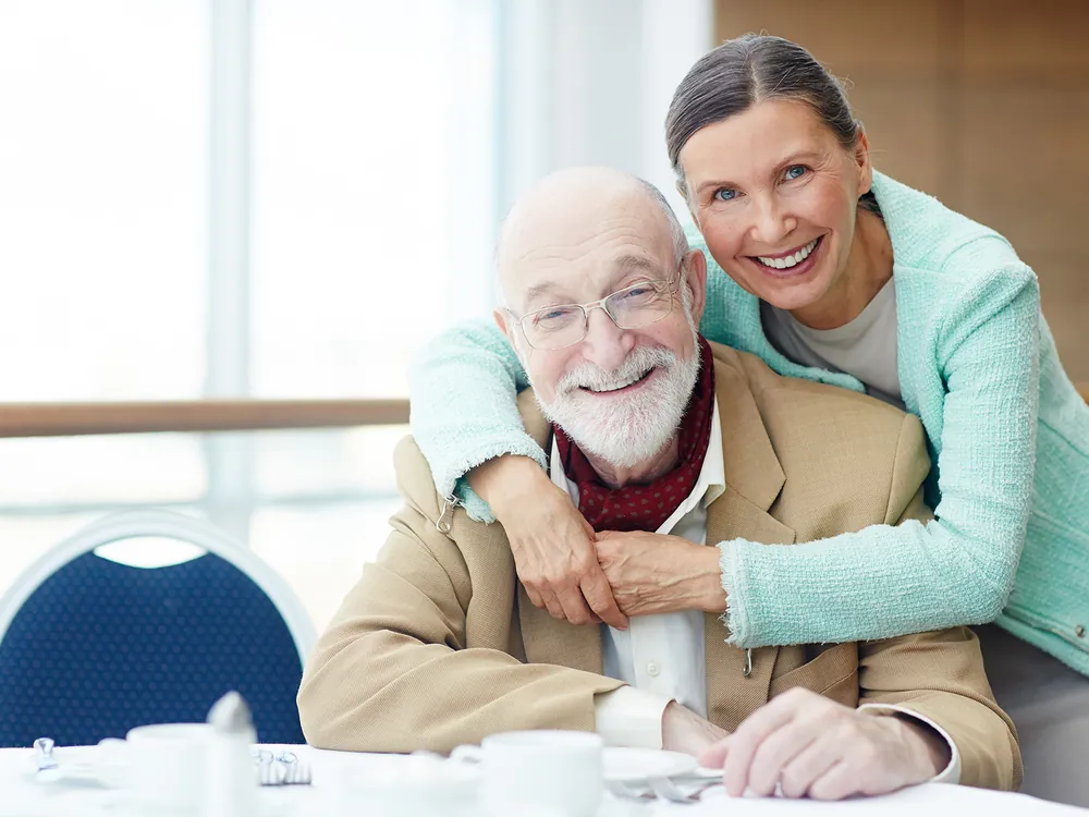 Senior man embraced by his daughter